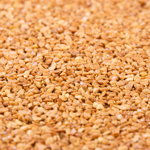 Nahaufnahme eines Steinteppichs mit kleinen, goldfarbenen Kieseln