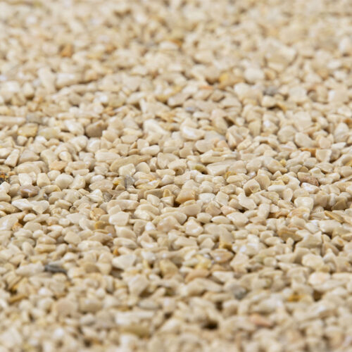 Detailaufnahme eines hellen Steinteppichs mit kleinen, beige farbenen Kieseln