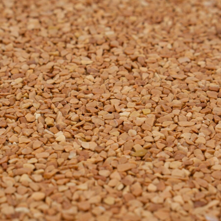 Nahaufnahme von rotem Marmorkies mit 2-4 mm Körnung, diagonal angeordnet