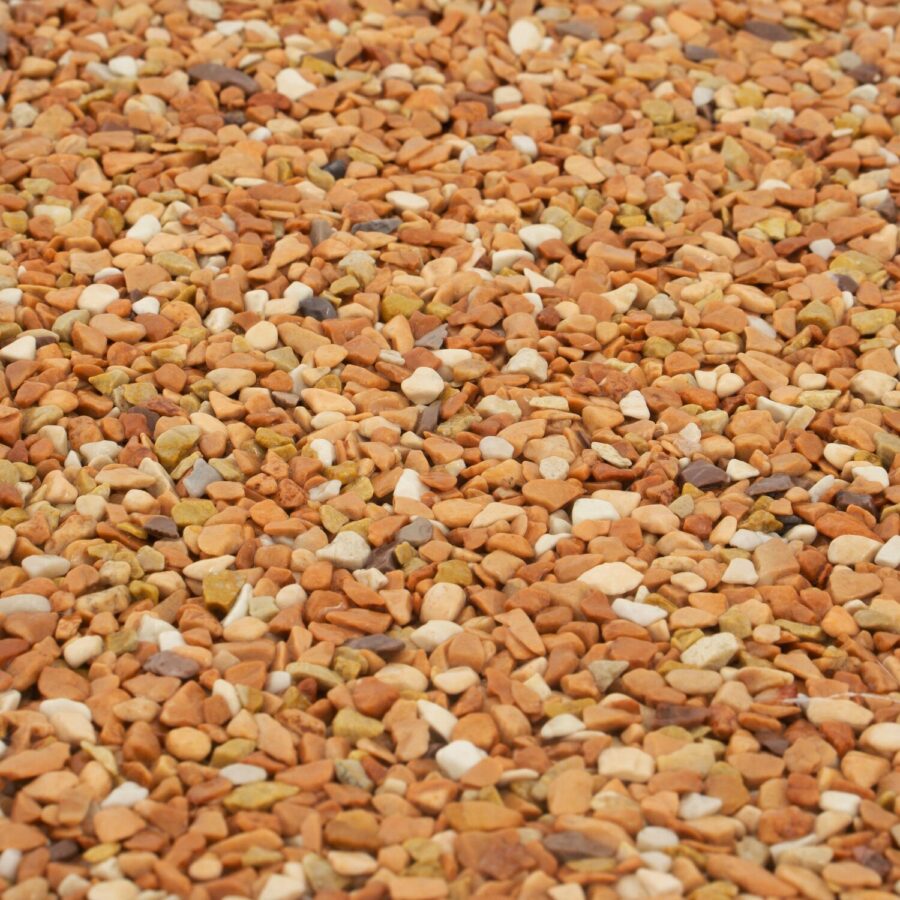 Nahaufnahme von körnigem Steinteppich in Weiß, Beige, Gelb und Rot