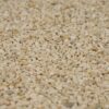Nahaufnahme von beige Marmorkies in 2-4 mm Körnung, unscharfer Hintergrund